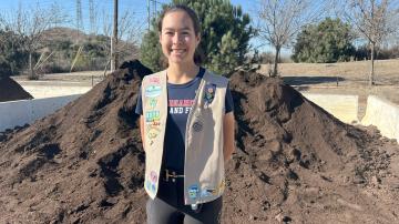 Photo of Bella in front of compost pile