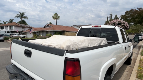 A picture of a car with a tarp covering the load