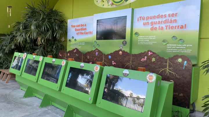 World of Organic Waste game at Discovery Cube. Five green monitors with TV learning display.