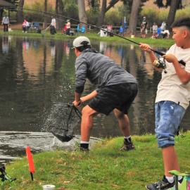 one kid and one adult fishing in lake