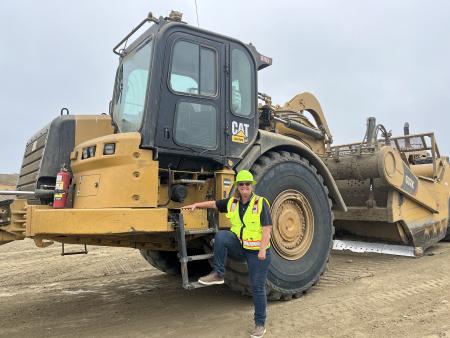 picture of our employee next to a machine at the landfill