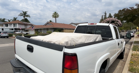 A picture of a car with a tarp covering the load